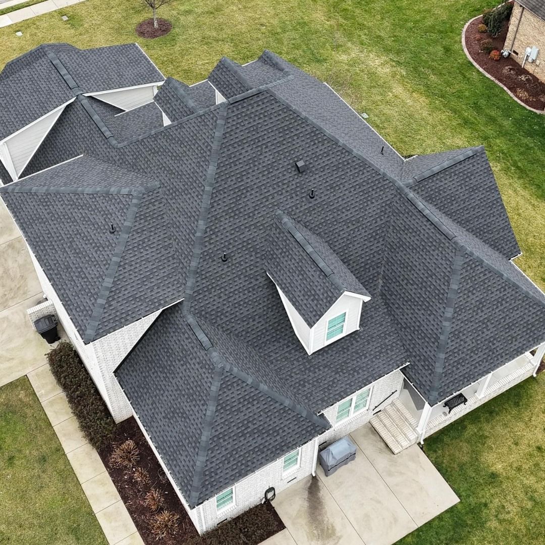 Aerial view of a dark gray architectural asphalt shingle roof on a large home